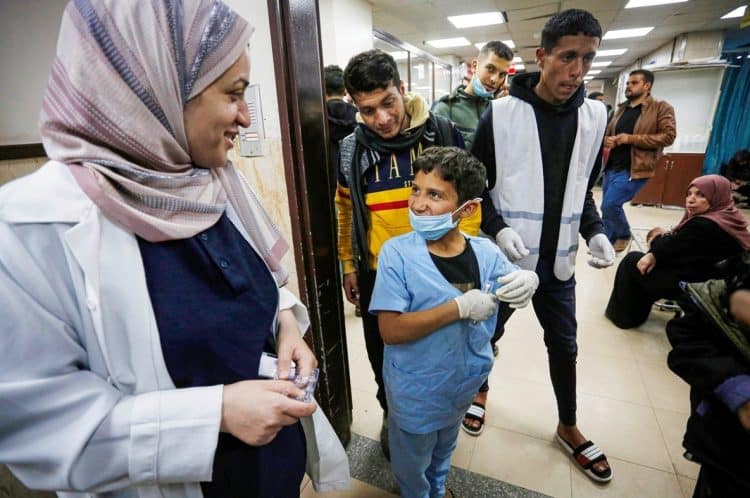 Palestinski dječak pomaže bolničkom osoblju u prijemu ranjenih