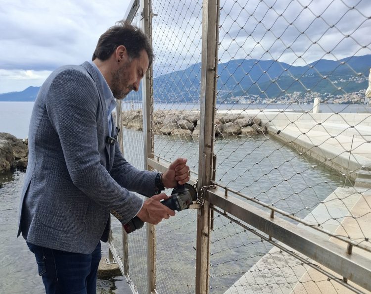 Marin Miletić brusilicom reže lokot na prolazu uz plažu kod Hiltona u Rijeci